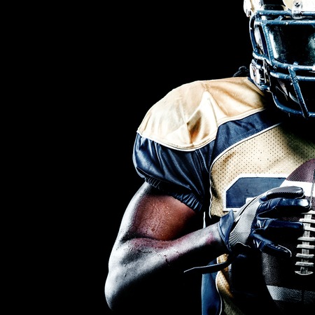 American football sportsman player isolated on black backgroundの写真素材