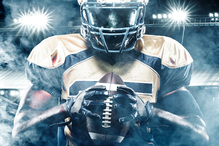 American football sportsman player on stadium with lights on backgroundの写真素材