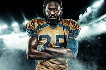 American football sportsman player on stadium with lights on backgroundの写真素材