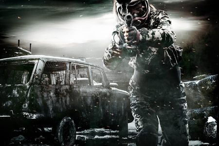 Heavily armed masked paintball soldier on post apocalyptic background. Ad concept.の写真素材