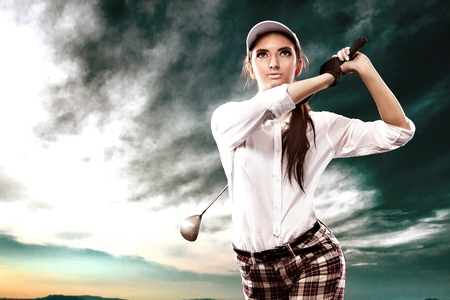 Woman golfer hitting the ball on the sky background. Copy space. Ad concept.の写真素材