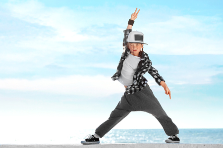 Happy little girl dancing on sky background. Copy space.の写真素材