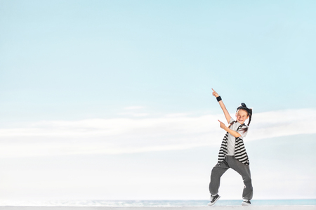 Happy little girl on sky background. Fashion kids. Copy space.の写真素材