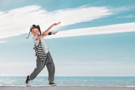 Happy little girl on sky background. Fashion kids. Copy space.の写真素材