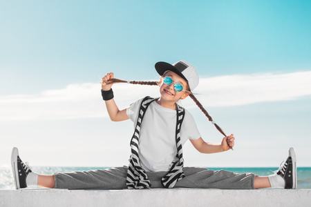 Fashion sport kid stretching over sky background.の写真素材