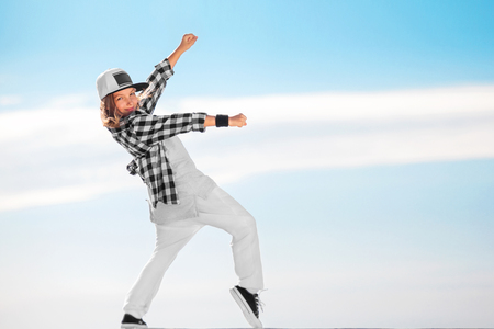 Fashion child dancing over sky background.の写真素材