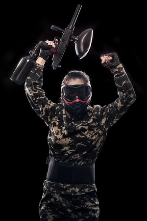 Heavily armed masked soldier isolated on black background. Paintball and lasertag sport games.の写真素材