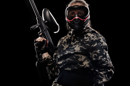 Heavily armed masked soldier isolated on black background. Paintball and lasertag sport games.の写真素材