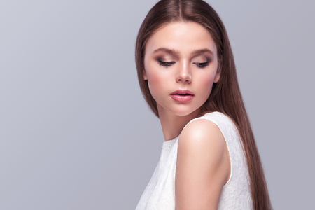 Charming young bride in wedding dress. Pretty girl in white. Gray background, copy space, place for your text.の写真素材