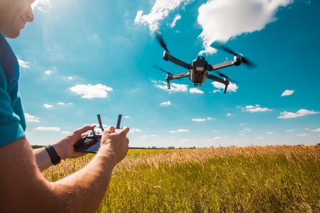 Demonstration of copter. Young hipster man with flying drone.の写真素材