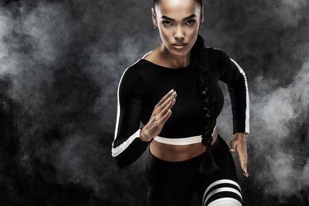 A strong athletic, woman sprinter, run. Girl wearing in the sportswear, fitness and sport motivation concept with copy space.の写真素材