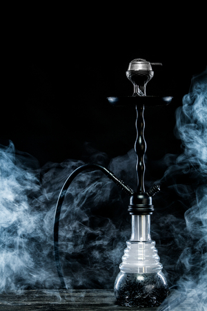 Hookah hot coals on bowl with black background. Stylish oriental shisha. Concept for bars and night...