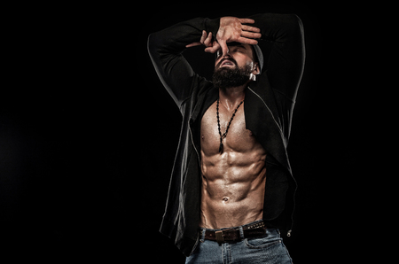 Handsome fit man posing wearing in jeans with tattoo. Sport and fashion concept isolated on black background.の写真素材