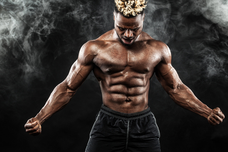 Sports wallpaper on dark background. Power athletic guy bodybuilder. Fire, smoke and energy.の写真素材