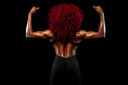 A strong athletic woman on black background wearing in sportswear, fitness and sport motivation. Sport concept with copy space.の写真素材