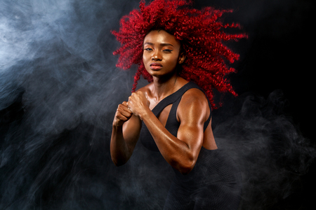 A strong athletic woman on black background wearing in sportswear, fitness and sport motivation. Sport concept with copy space.の写真素材
