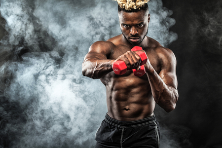Muscular young fitness sports man workout with dumbbell in fitness gymの写真素材
