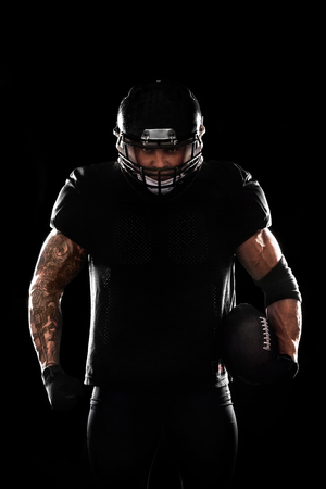 American football sportsman player isolated on black backgroundの写真素材