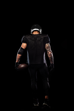 American football sportsman player isolated on black backgroundの写真素材