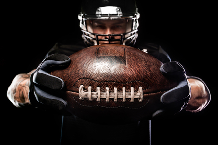 American football sportsman player isolated on black backgroundの写真素材