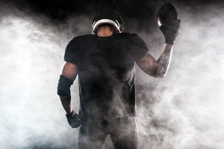 American football sportsman player isolated on black backgroundの写真素材