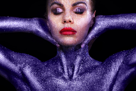 Portrait of nude girl body painted with tinsel and sparkles on black backgroundの写真素材