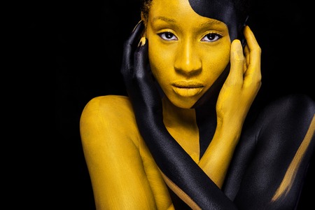 Cheerful young african woman with art fashion makeup. An amazing woman with black and yellow makeupの写真素材