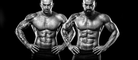 Handsome fit man posing with tattoo. Sport and fashion concept isolated on black background.の写真素材
