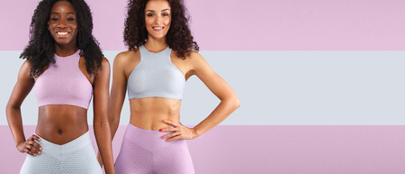 Two fitness women in sportswear isolated over gray background. Sport and fashion concept wit chopy space.の写真素材