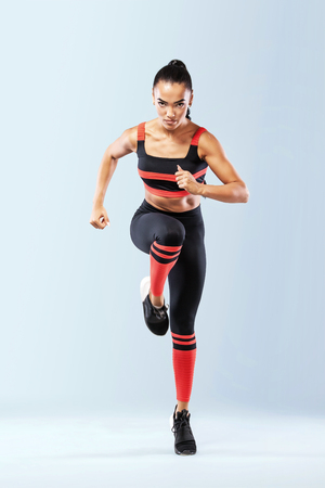 A strong athletic, women sprinter, running wearing in the sportswear, fitness and sport motivation. Runner concept with copy space. Dynamic movementの写真素材
