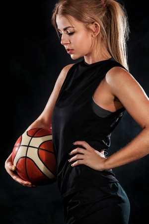 Portrait of a beautiful and sexy girl with a basketball in studio. Sport conceptの写真素材