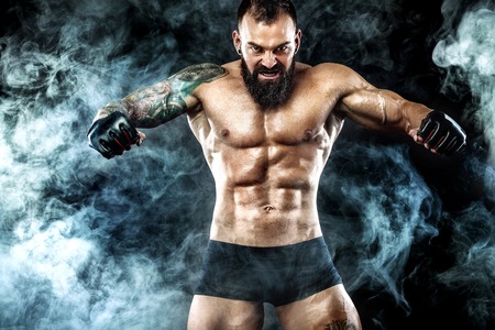 Sportsman boxer fighting on black background with smoke. Copy Space. Boxing sport concept.の写真素材