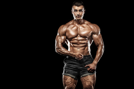 Muscular young fitness sports man. Workout with dumbbell in fitness gym. Copy space for fitness nutrition ads.の写真素材