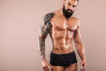 Muscular young fitness sports man with strong fit body on light background.の写真素材