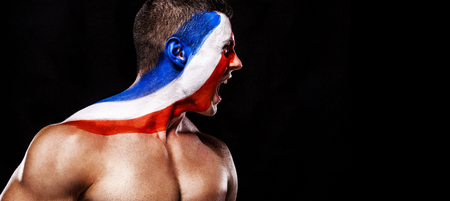 Soccer or football fan with bodyart on face with agression - flag of France.の写真素材