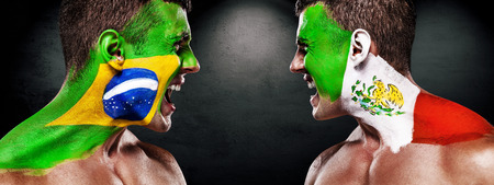 Soccer or football fan with bodyart on face with agression - flags of Brazil vs Mexico.の写真素材