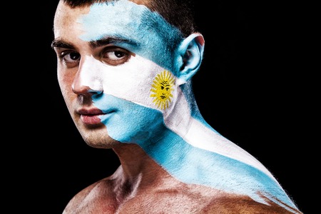 Soccer or football fan with bodyart on face with agression - flag of Argentina.の写真素材