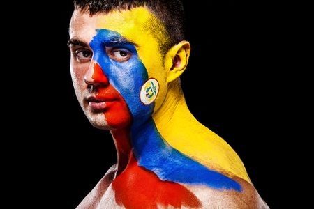 Soccer or football fan with bodyart on face with agression - flag of Colombia.の写真素材