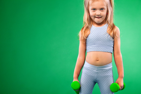 Kid doing fitness exercises at home in her roomの写真素材