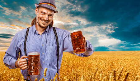 Half-length portrait of young man holding the beer mug.の写真素材