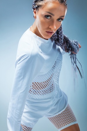 Attractive excited fitness girl dancer in sportwear dance isolated over blue background. Fashion and livestyle concept.の写真素材