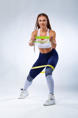 Muscular young fit sports woman athlete. Workout with bands or expander in gym. Copy space for...