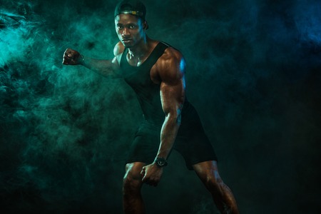 Sports men athlete on dark background. Power athletic guy bodybuilder doing fitness training.の写真素材