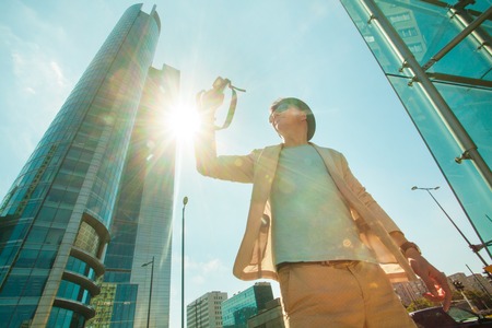 Man makes photo shoot of skyscrapers in the big city. Travel and lifestyle concept.の写真素材