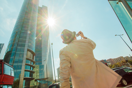 Man makes photo shoot of skyscrapers in the big city. Travel and lifestyle concept.の写真素材