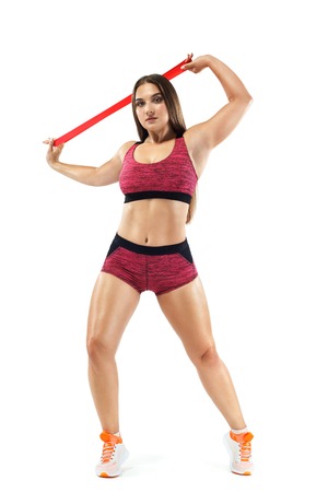 Fitness woman athlete and bodybuilder holding expander. Isolated on white background.の写真素材