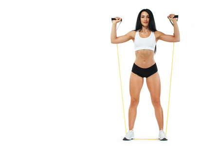 Fitness woman athlete and bodybuilder holding espander. Isolated on white background. Copy spaceの写真素材