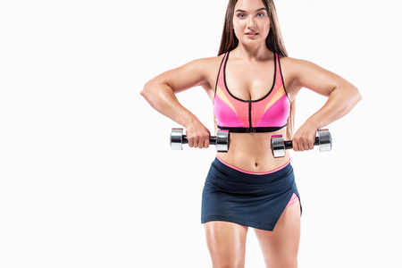 Attractive young fitness woman athlete and bodybuilder holding dumbbell on white background.の写真素材
