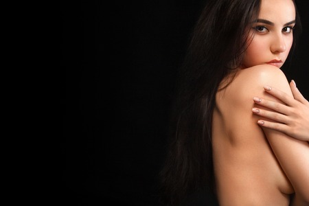 Picture of sexy young nude lady isolated on black background, stylish woman with dark hair, pretty female with naked shoulder, sensuality and beauty conceptの写真素材