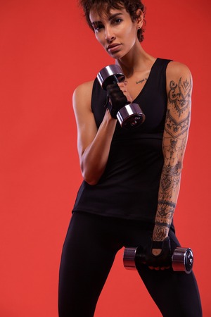 A Strong athletic, female runner on the black background wearing a tight, fitness outfit.の写真素材